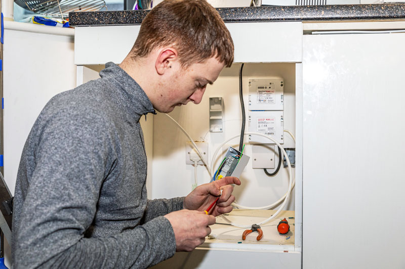 Technician fitting a Firechief Kitchen Stove Guard in apartments